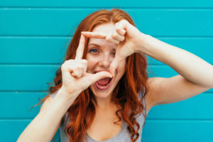 A woman making a camera sign with her hands